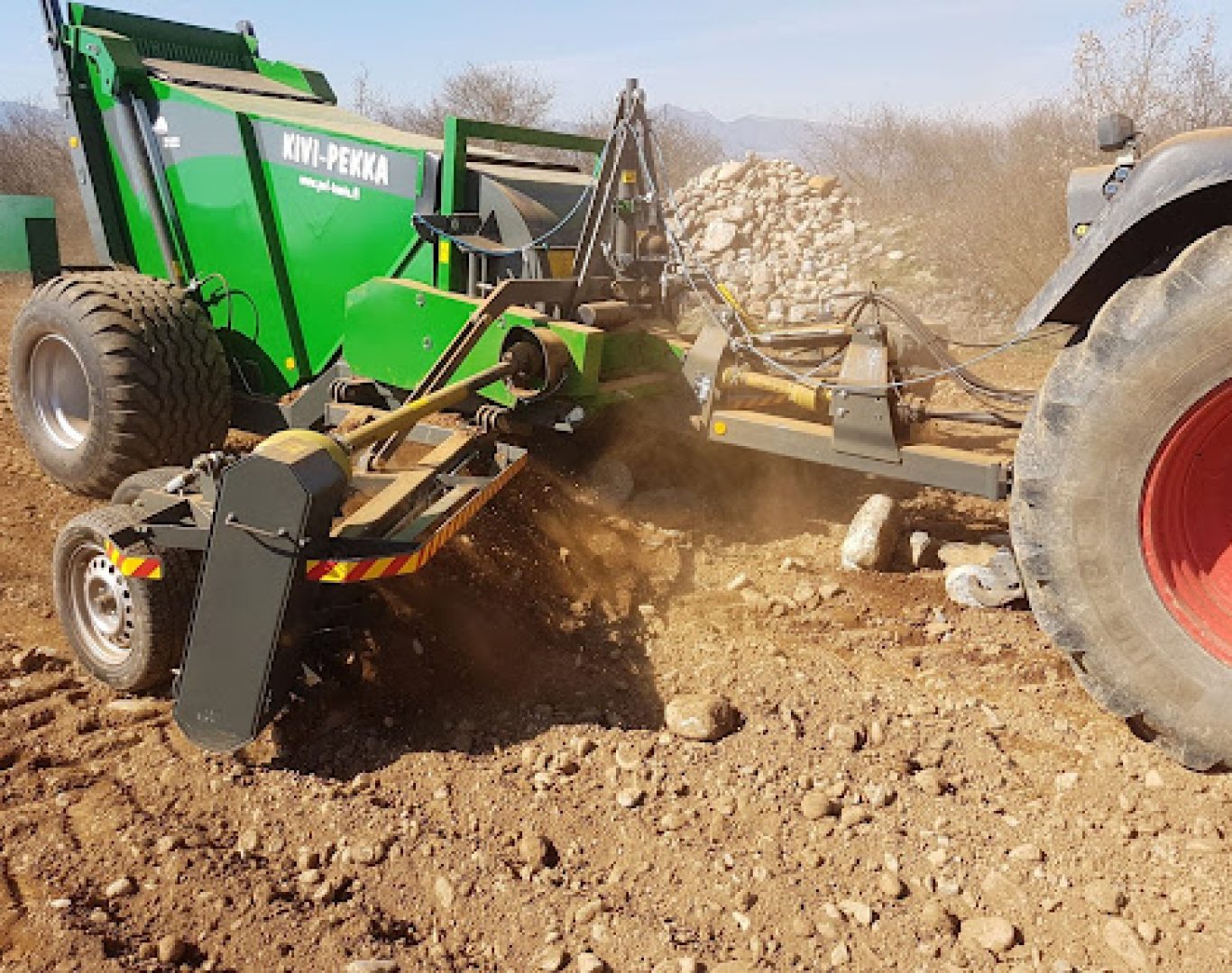 img Equipment Needed for Rock Removal Excavator lifting large limestone boulders during rock removal on Texas property